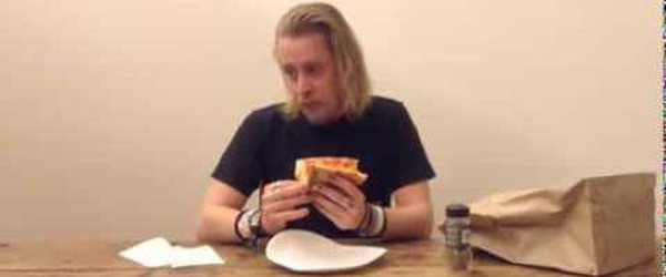 Macaulay Culkin Eating a Slice of Pizza